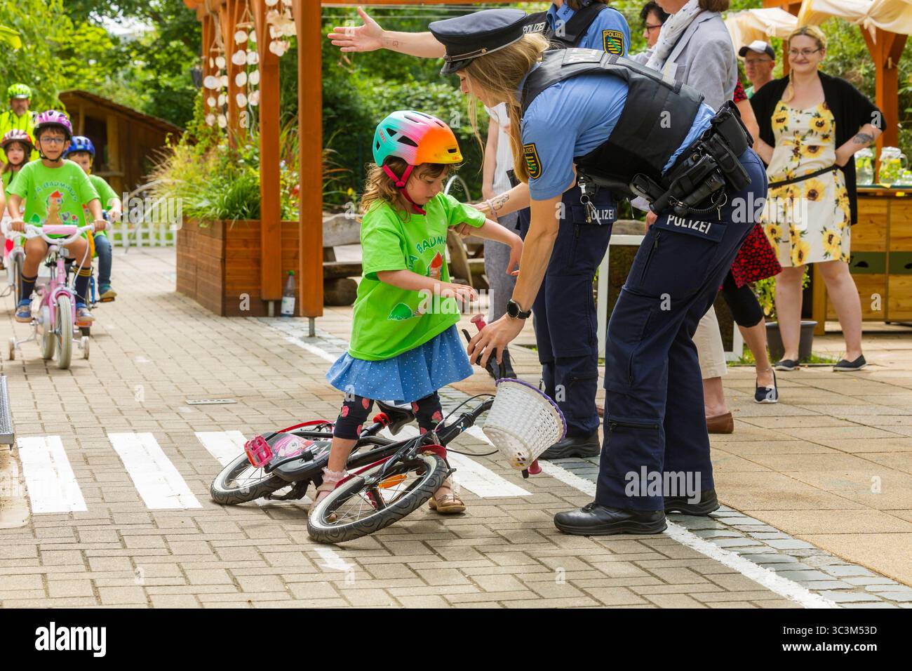 Presse- und Fototermin zur Verkehrssicherheit in der Kita Baumhaus die Dresdner Kita BAUMHAUS mit ihrem naturpädagogischen Schwerpunkt. Die gute Verkehrsanbindung birgt aber zum Teil komplexe Herausforderungen für die künftigen Schulkinder. Durch gezielte Übungen, Rollenspiele und gemeinsame Spaziergänge mit ihren Erzieherinnen und Erziehern können die Kinder ein Gefühl für sichere Verhaltensweisen im Straßenraum entwickeln. Einmal im Jahr bringen Bürgerpolizisten den Vorschulkindern die wichtigsten Verkehrsregeln auf spielerische Weise näher. Die Kinder wurden sensibilisiert, Gefahren m Stockfoto