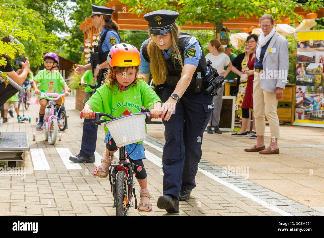 Presse- und Fototermin zur Verkehrssicherheit in der Kita Baumhaus die Dresdner Kita BAUMHAUS mit ihrem naturpädagogischen Schwerpunkt. Die gute Verkehrsanbindung birgt aber zum Teil komplexe Herausforderungen für die künftigen Schulkinder. Durch gezielte Übungen, Rollenspiele und gemeinsame Spaziergänge mit ihren Erzieherinnen und Erziehern können die Kinder ein Gefühl für sichere Verhaltensweisen im Straßenraum entwickeln. Einmal im Jahr bringen Bürgerpolizisten den Vorschulkindern die wichtigsten Verkehrsregeln auf spielerische Weise näher. Die Kinder wurden sensibilisiert, Gefahren m Stockfoto