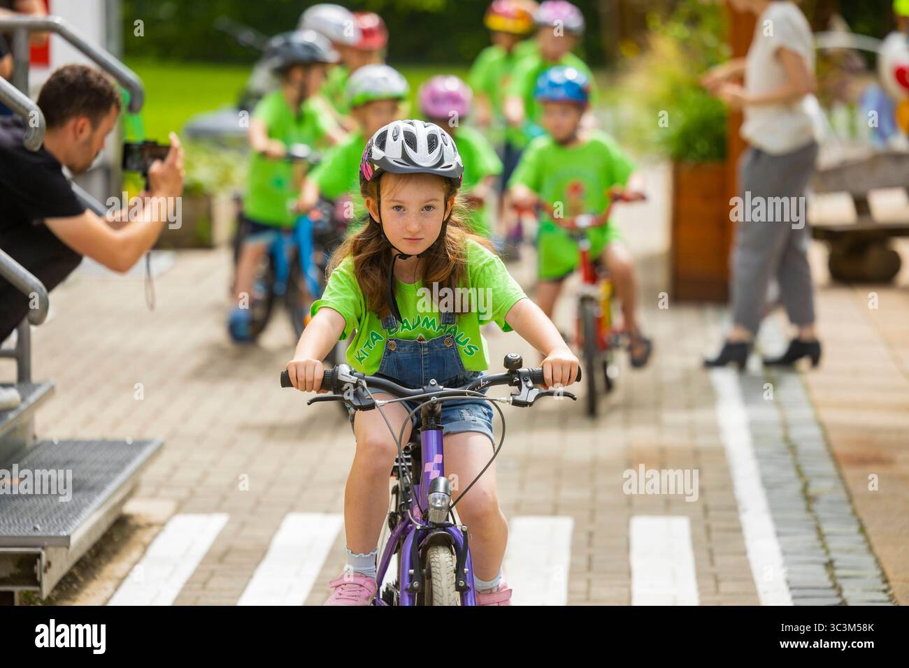 Presse- und Fototermin zur Verkehrssicherheit in der Kita Baumhaus die Dresdner Kita BAUMHAUS mit ihrem naturpädagogischen Schwerpunkt. Die gute Verkehrsanbindung birgt aber zum Teil komplexe Herausforderungen für die künftigen Schulkinder. Durch gezielte Übungen, Rollenspiele und gemeinsame Spaziergänge mit ihren Erzieherinnen und Erziehern können die Kinder ein Gefühl für sichere Verhaltensweisen im Straßenraum entwickeln. Einmal im Jahr bringen Bürgerpolizisten den Vorschulkindern die wichtigsten Verkehrsregeln auf spielerische Weise näher. Die Kinder wurden sensibilisiert, Gefahren m Stockfoto