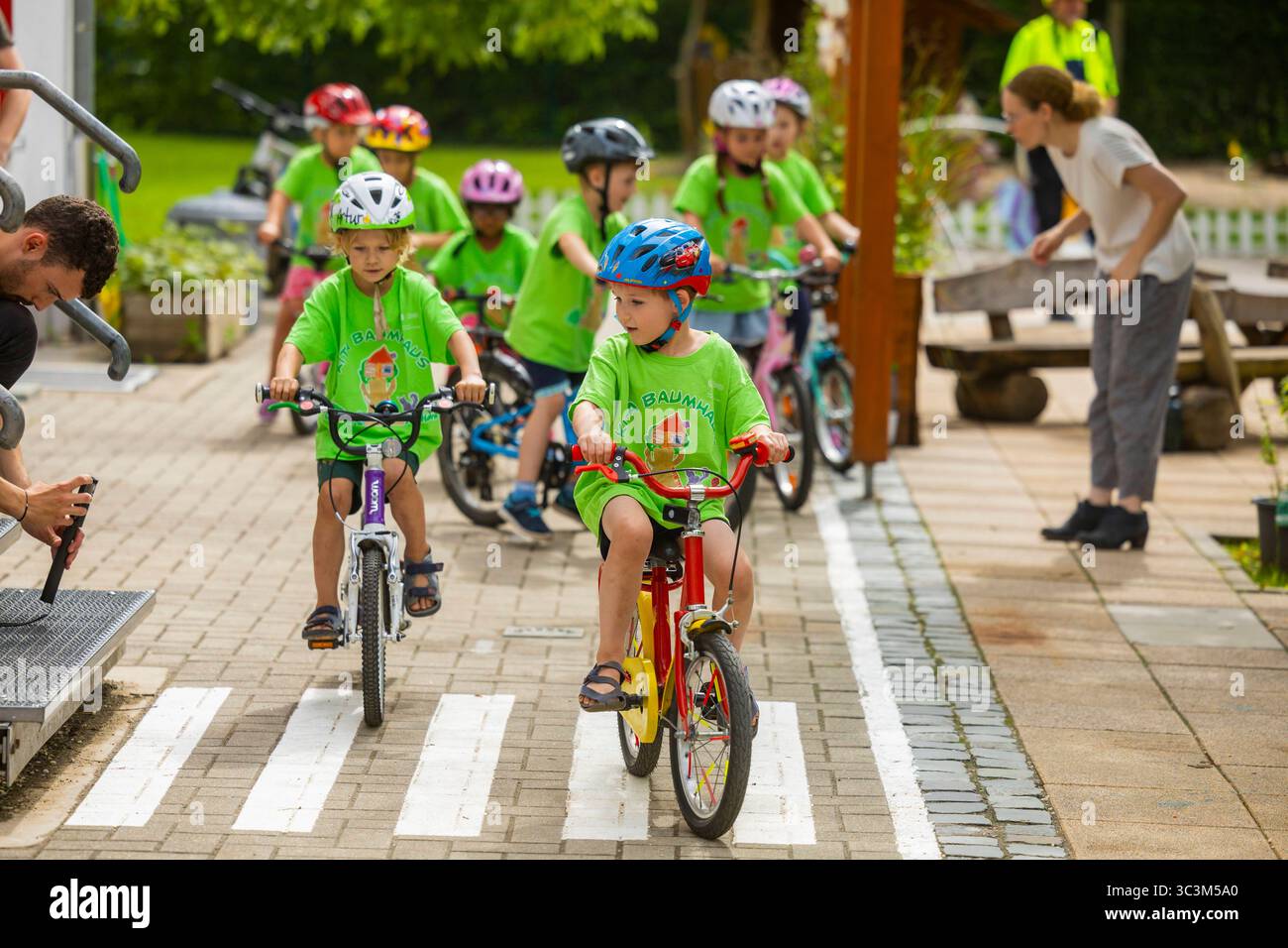 Presse- und Fototermin zur Verkehrssicherheit in der Kita Baumhaus die Dresdner Kita BAUMHAUS mit ihrem naturpädagogischen Schwerpunkt. Die gute Verkehrsanbindung birgt aber zum Teil komplexe Herausforderungen für die künftigen Schulkinder. Durch gezielte Übungen, Rollenspiele und gemeinsame Spaziergänge mit ihren Erzieherinnen und Erziehern können die Kinder ein Gefühl für sichere Verhaltensweisen im Straßenraum entwickeln. Einmal im Jahr bringen Bürgerpolizisten den Vorschulkindern die wichtigsten Verkehrsregeln auf spielerische Weise näher. Die Kinder wurden sensibilisiert, Gefahren m Stockfoto