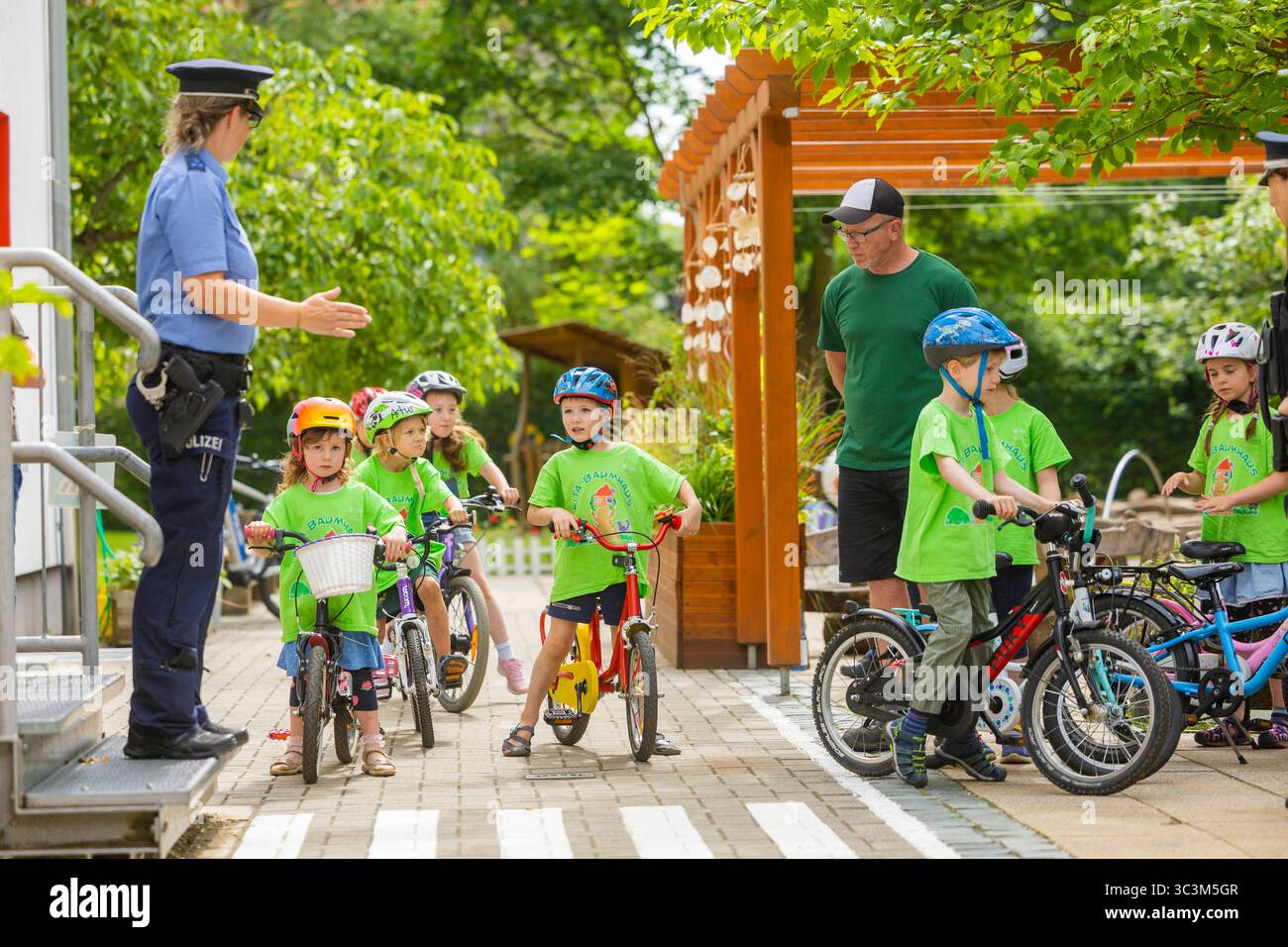 Presse- und Fototermin zur Verkehrssicherheit in der Kita Baumhaus die Dresdner Kita BAUMHAUS mit ihrem naturpädagogischen Schwerpunkt. Die gute Verkehrsanbindung birgt aber zum Teil komplexe Herausforderungen für die künftigen Schulkinder. Durch gezielte Übungen, Rollenspiele und gemeinsame Spaziergänge mit ihren Erzieherinnen und Erziehern können die Kinder ein Gefühl für sichere Verhaltensweisen im Straßenraum entwickeln. Einmal im Jahr bringen Bürgerpolizisten den Vorschulkindern die wichtigsten Verkehrsregeln auf spielerische Weise näher. Die Kinder wurden sensibilisiert, Gefahren m Stockfoto