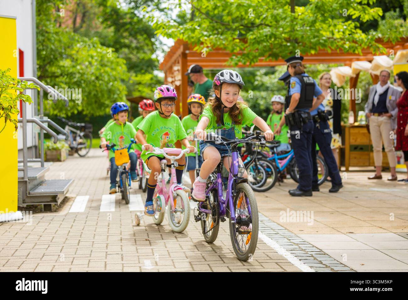 Presse- und Fototermin zur Verkehrssicherheit in der Kita Baumhaus die Dresdner Kita BAUMHAUS mit ihrem naturpädagogischen Schwerpunkt. Die gute Verkehrsanbindung birgt aber zum Teil komplexe Herausforderungen für die künftigen Schulkinder. Durch gezielte Übungen, Rollenspiele und gemeinsame Spaziergänge mit ihren Erzieherinnen und Erziehern können die Kinder ein Gefühl für sichere Verhaltensweisen im Straßenraum entwickeln. Einmal im Jahr bringen Bürgerpolizisten den Vorschulkindern die wichtigsten Verkehrsregeln auf spielerische Weise näher. Die Kinder wurden sensibilisiert, Gefahren m Stockfoto