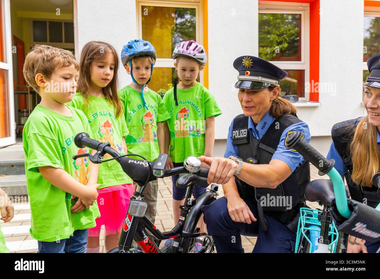 Presse- und Fototermin zur Verkehrssicherheit in der Kita Baumhaus die Dresdner Kita BAUMHAUS mit ihrem naturpädagogischen Schwerpunkt. Die gute Verkehrsanbindung birgt aber zum Teil komplexe Herausforderungen für die künftigen Schulkinder. Durch gezielte Übungen, Rollenspiele und gemeinsame Spaziergänge mit ihren Erzieherinnen und Erziehern können die Kinder ein Gefühl für sichere Verhaltensweisen im Straßenraum entwickeln. Einmal im Jahr bringen Bürgerpolizisten den Vorschulkindern die wichtigsten Verkehrsregeln auf spielerische Weise näher. Die Kinder wurden sensibilisiert, Gefahren m Stockfoto