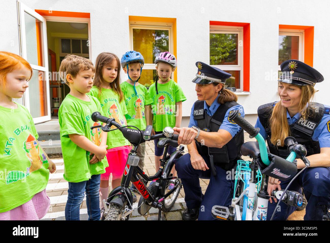 Presse- und Fototermin zur Verkehrssicherheit in der Kita Baumhaus die Dresdner Kita BAUMHAUS mit ihrem naturpädagogischen Schwerpunkt. Die gute Verkehrsanbindung birgt aber zum Teil komplexe Herausforderungen für die künftigen Schulkinder. Durch gezielte Übungen, Rollenspiele und gemeinsame Spaziergänge mit ihren Erzieherinnen und Erziehern können die Kinder ein Gefühl für sichere Verhaltensweisen im Straßenraum entwickeln. Einmal im Jahr bringen Bürgerpolizisten den Vorschulkindern die wichtigsten Verkehrsregeln auf spielerische Weise näher. Die Kinder wurden sensibilisiert, Gefahren m Stockfoto