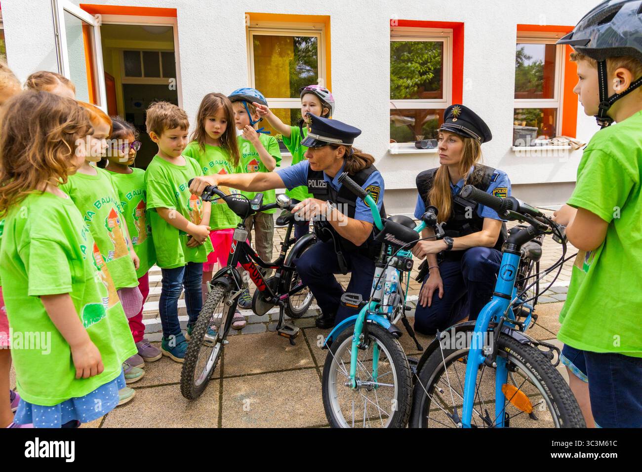 Presse- und Fototermin zur Verkehrssicherheit in der Kita Baumhaus die Dresdner Kita BAUMHAUS mit ihrem naturpädagogischen Schwerpunkt. Die gute Verkehrsanbindung birgt aber zum Teil komplexe Herausforderungen für die künftigen Schulkinder. Durch gezielte Übungen, Rollenspiele und gemeinsame Spaziergänge mit ihren Erzieherinnen und Erziehern können die Kinder ein Gefühl für sichere Verhaltensweisen im Straßenraum entwickeln. Einmal im Jahr bringen Bürgerpolizisten den Vorschulkindern die wichtigsten Verkehrsregeln auf spielerische Weise näher. Die Kinder wurden sensibilisiert, Gefahren m Stockfoto