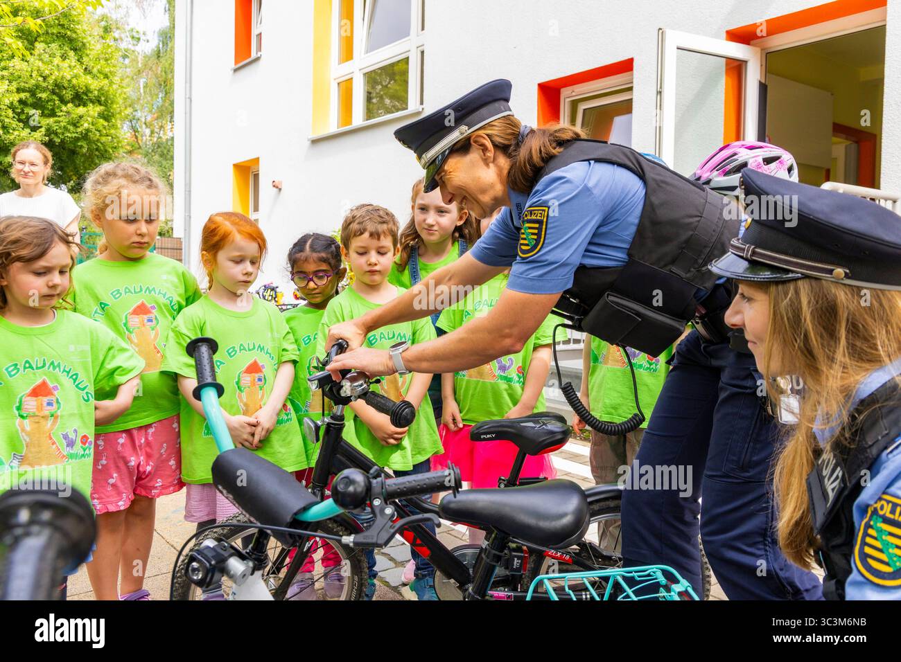 Presse- und Fototermin zur Verkehrssicherheit in der Kita Baumhaus die Dresdner Kita BAUMHAUS mit ihrem naturpädagogischen Schwerpunkt. Die gute Verkehrsanbindung birgt aber zum Teil komplexe Herausforderungen für die künftigen Schulkinder. Durch gezielte Übungen, Rollenspiele und gemeinsame Spaziergänge mit ihren Erzieherinnen und Erziehern können die Kinder ein Gefühl für sichere Verhaltensweisen im Straßenraum entwickeln. Einmal im Jahr bringen Bürgerpolizisten den Vorschulkindern die wichtigsten Verkehrsregeln auf spielerische Weise näher. Die Kinder wurden sensibilisiert, Gefahren m Stockfoto