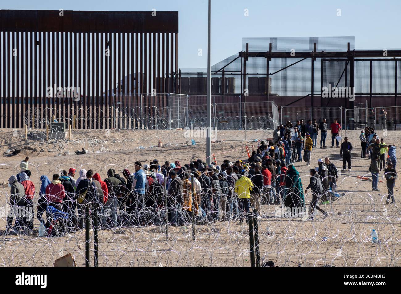 An der Grenze zu Ciudad Juarez treffen sich Menschen, die auf die Herausforderungen der Migration hinweisen. Stockfoto