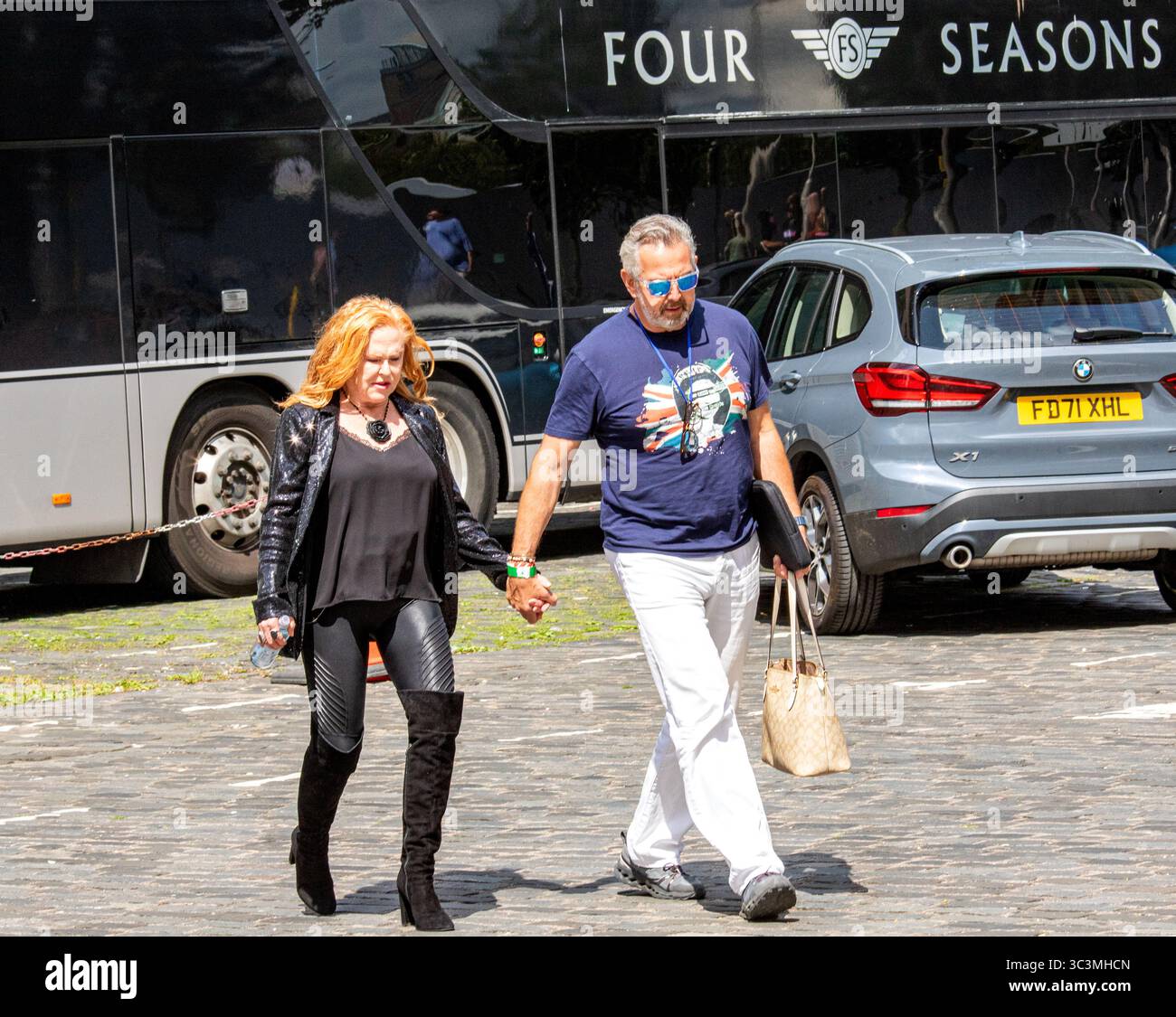 Dundee, Tayside, Schottland, Vereinigtes Königreich. Juli 2025. Carol Decker von der 1980er-Band T’Pau mit ihrem Ehemann Richard Coates kommt hinter der Bühne in Dundee Slessor Gardens an. Das Discovery Festival in Dundee veranstaltet die 80er Jahre Calling, eine Musikshow mit Bands aus den 1980er Jahren Vom 25. Bis 27. Juli 2025. Quelle: Dundee Photographics/Alamy Live News Stockfoto