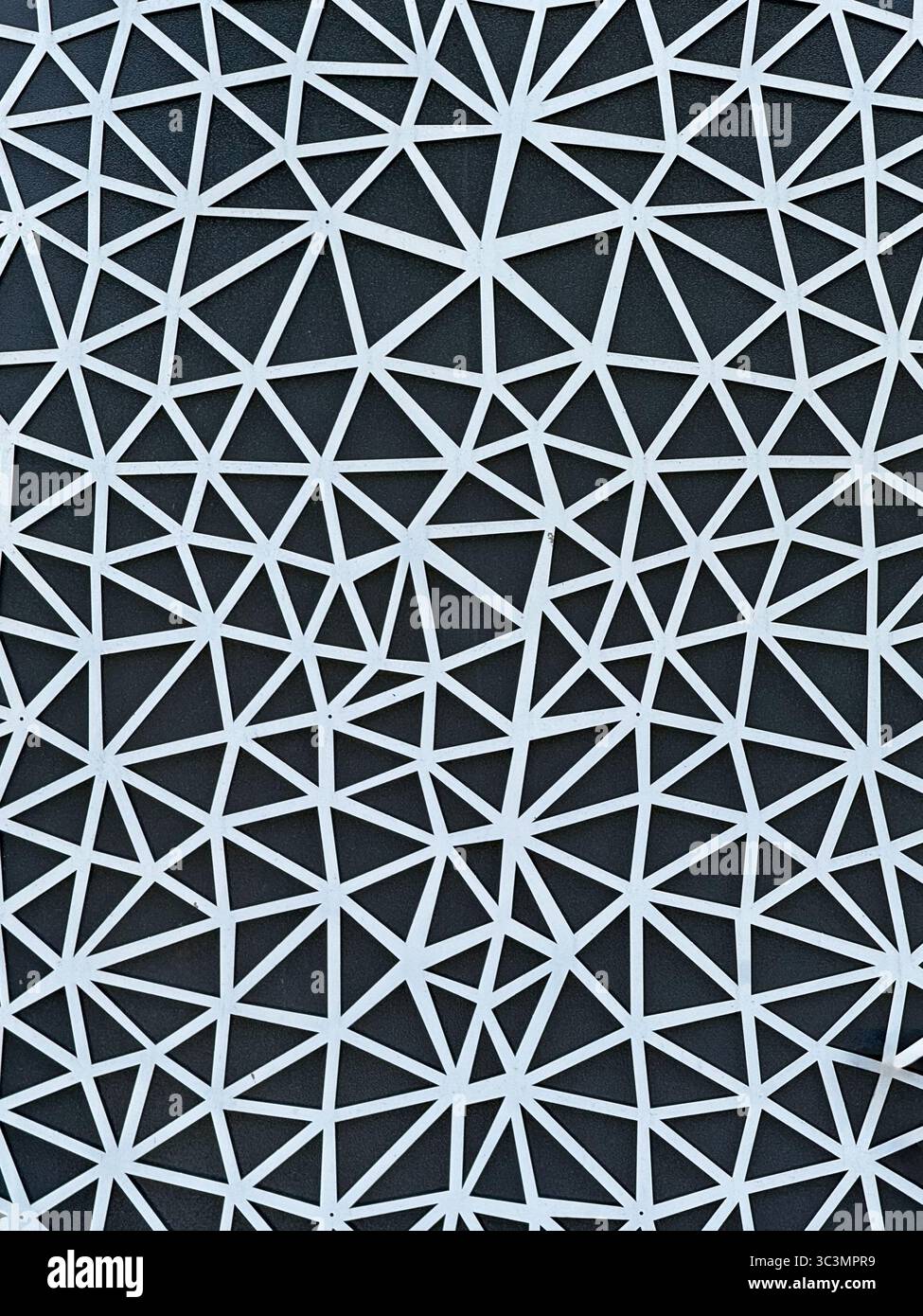 Abstraktes geometrisches Muster mit miteinander verbundenen Dreiecken in modernem Architekturdesign, das Symmetrie und Komplexität gegenüber einem Kontrast hervorhebt Stockfoto