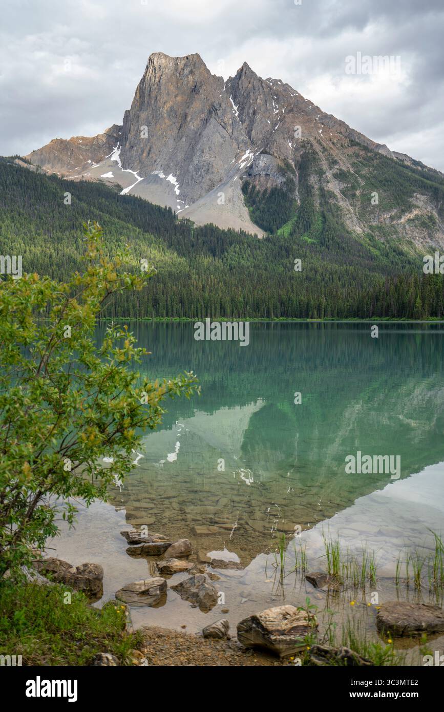 Erleben Sie die majestätische Schönheit der kanadischen Rocky Mountains mit dieser atemberaubenden Aussicht. Kristallklares Seenwasser reflektiert hohe Gipfel unter einer vibra Stockfoto