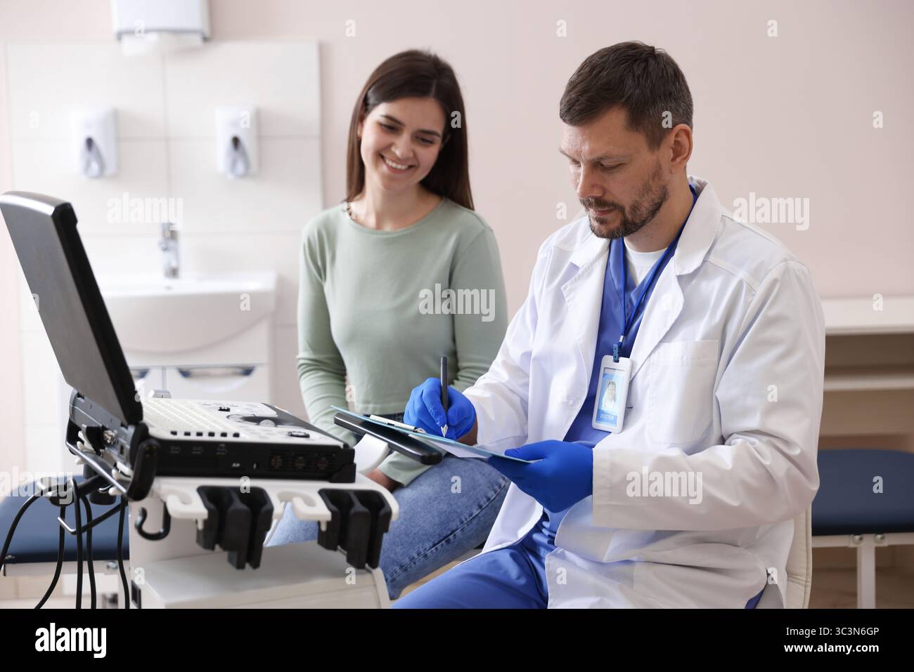 Sonographin berät Frau vor ihrer Ultraschalluntersuchung in der Klinik Stockfoto