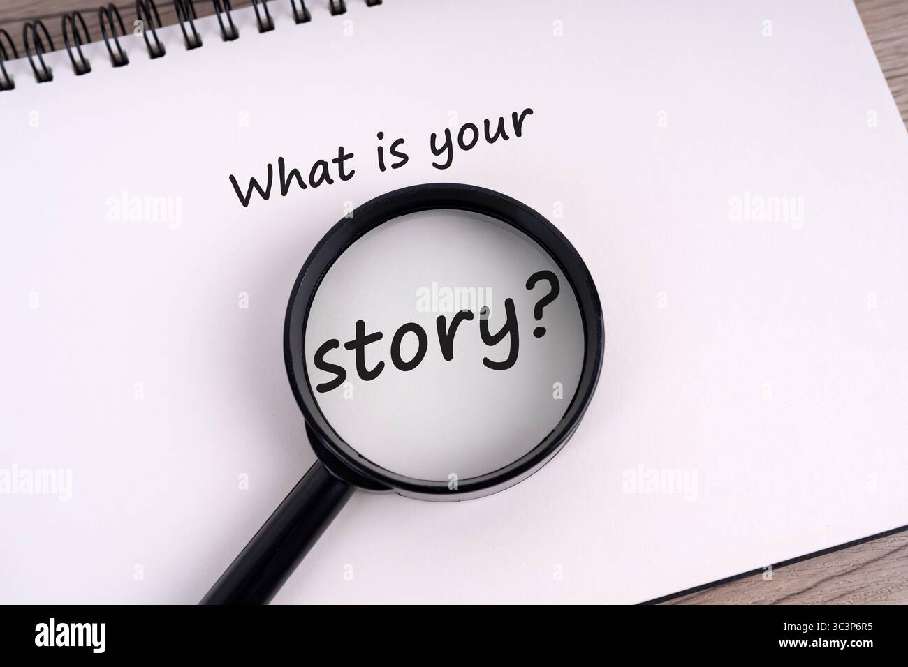 Was ist deine Geschichte? Text auf Notizblock und Lupe Stockfoto
