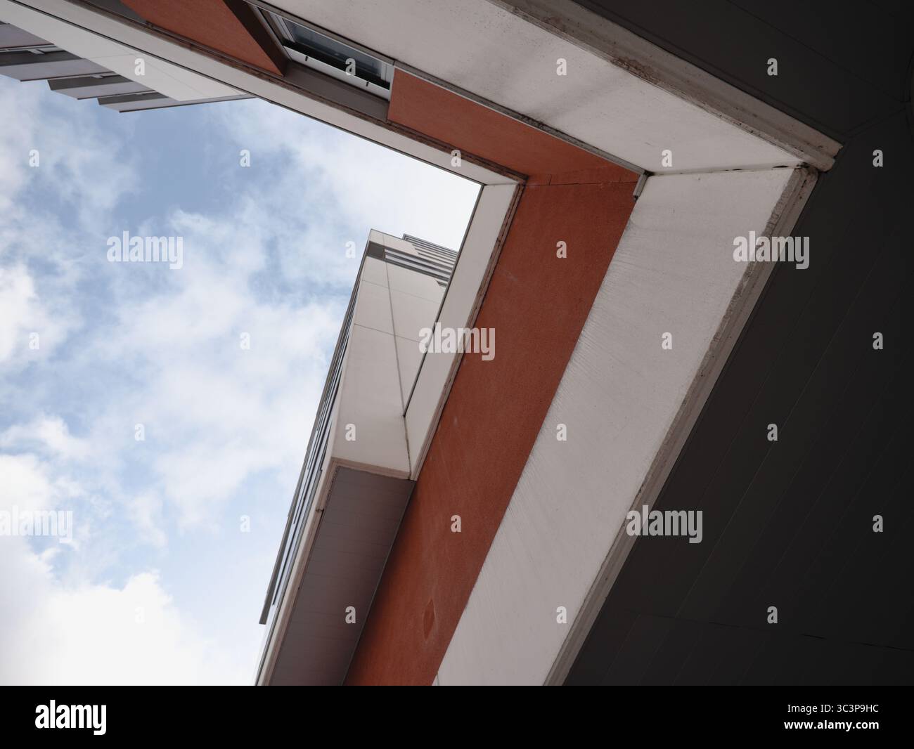 Flacher Blick auf ein modernes Gebäude mit rot-weißen Außenflächen, minimalistisches architektonisches Design. Stockfoto