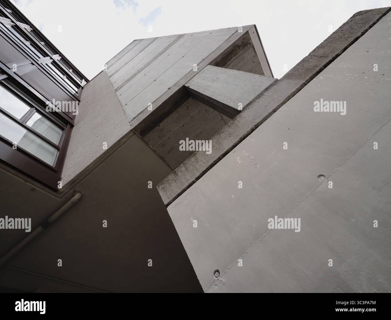 Perspektivische Fassade eines städtischen Gebäudes in einem linearen und modernen Stil. Graue Farben und schlecht verzierte Dekoration dominieren Stockfoto