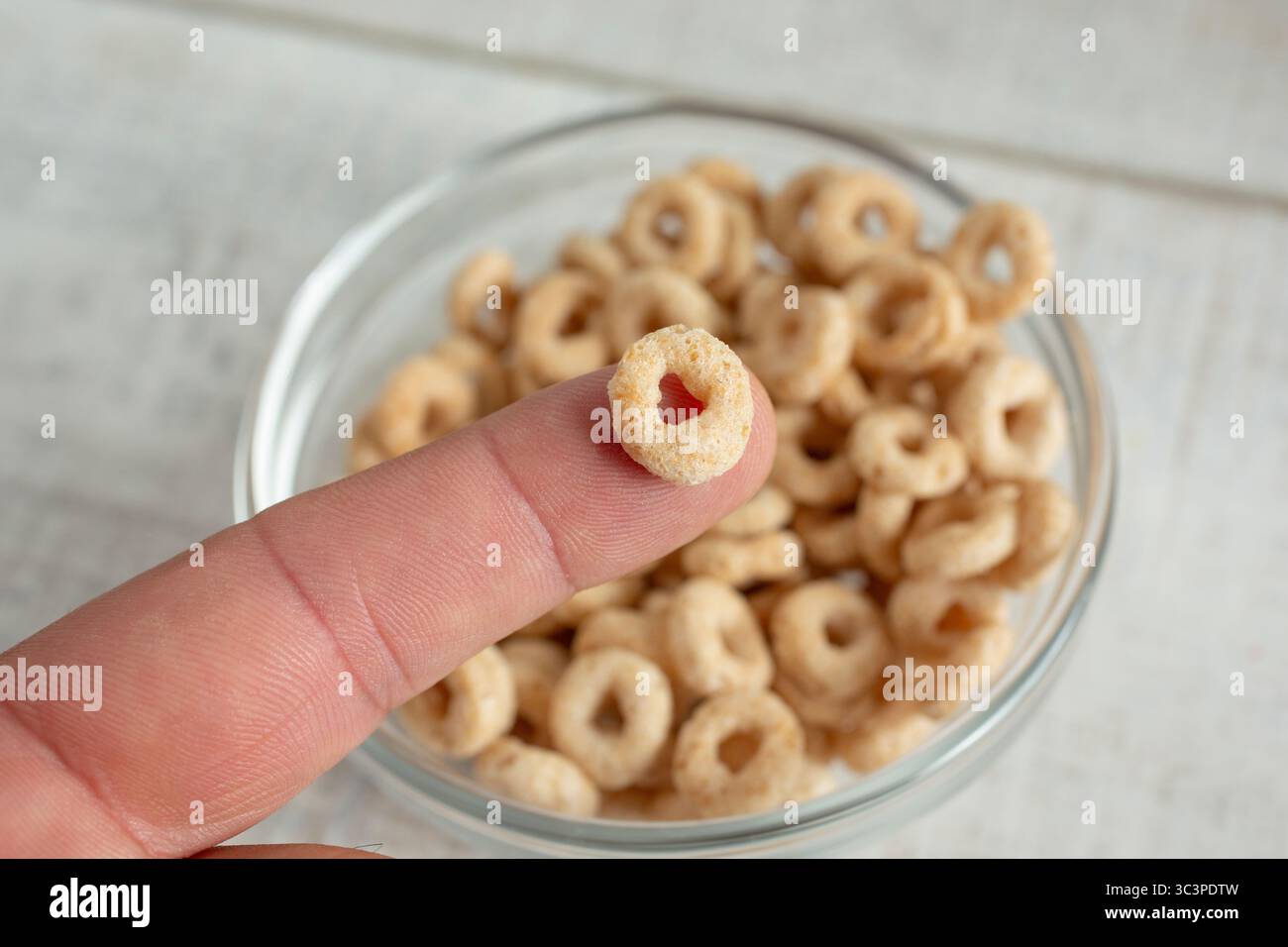 Ein Blick auf ein getoastetes Oh-Müsli an der Fingerspitze. Stockfoto