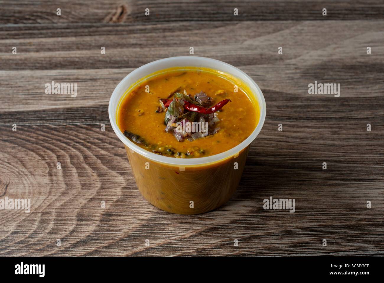 Blick auf einen Kunststoffbehälter mit Dhal-Butterbraten. Stockfoto