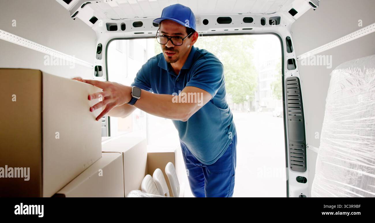 Liefermann, Der Kisten Für Den Kurierdienst In Den Fahrenden Lkw Lädt. Stockfoto