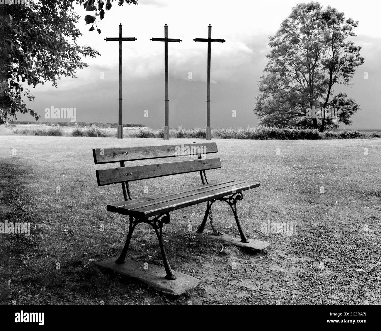 Drei hölzerne Kreuze gegen einen stürmischen Himmel. Schwarzweißfoto Stockfoto
