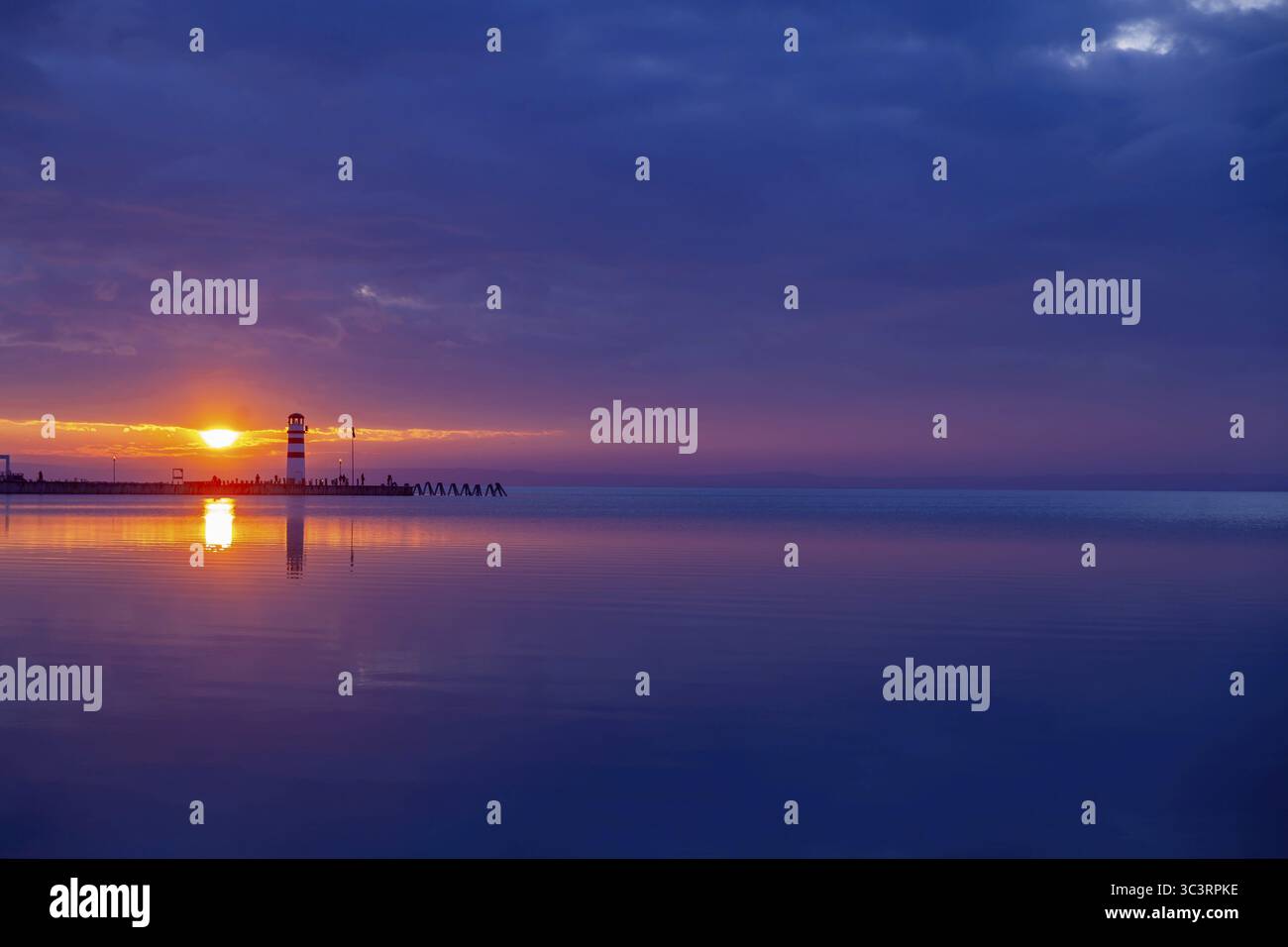 Leuchtturm bei Sonnenuntergang, umgeben von Violett- und Orangetönen Podersdorf Neusiedler See Burgenland Österreich Stockfoto