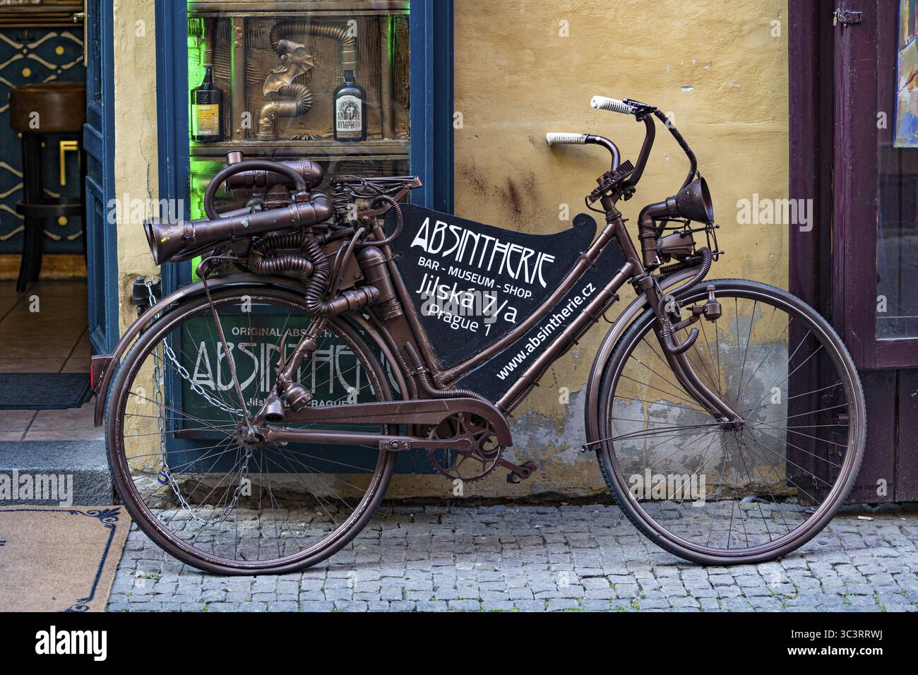 Ein dekoratives Fahrrad mit Vintage-Werbung vor einem historischen Geschäft in Prag, Tschechien Stockfoto