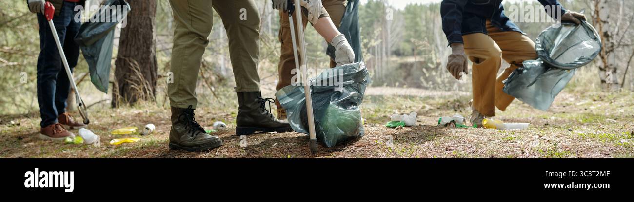 Gruppe von jungen Erwachsenen und Menschen mittleren Alters sammelt Müll im Freien Stockfoto