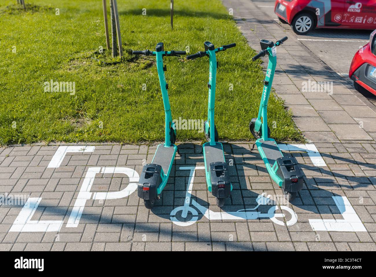 Elektroroller parken am ausgewiesenen Rollerparkplatz auf dem Bürgersteig der Stadt Stockfoto