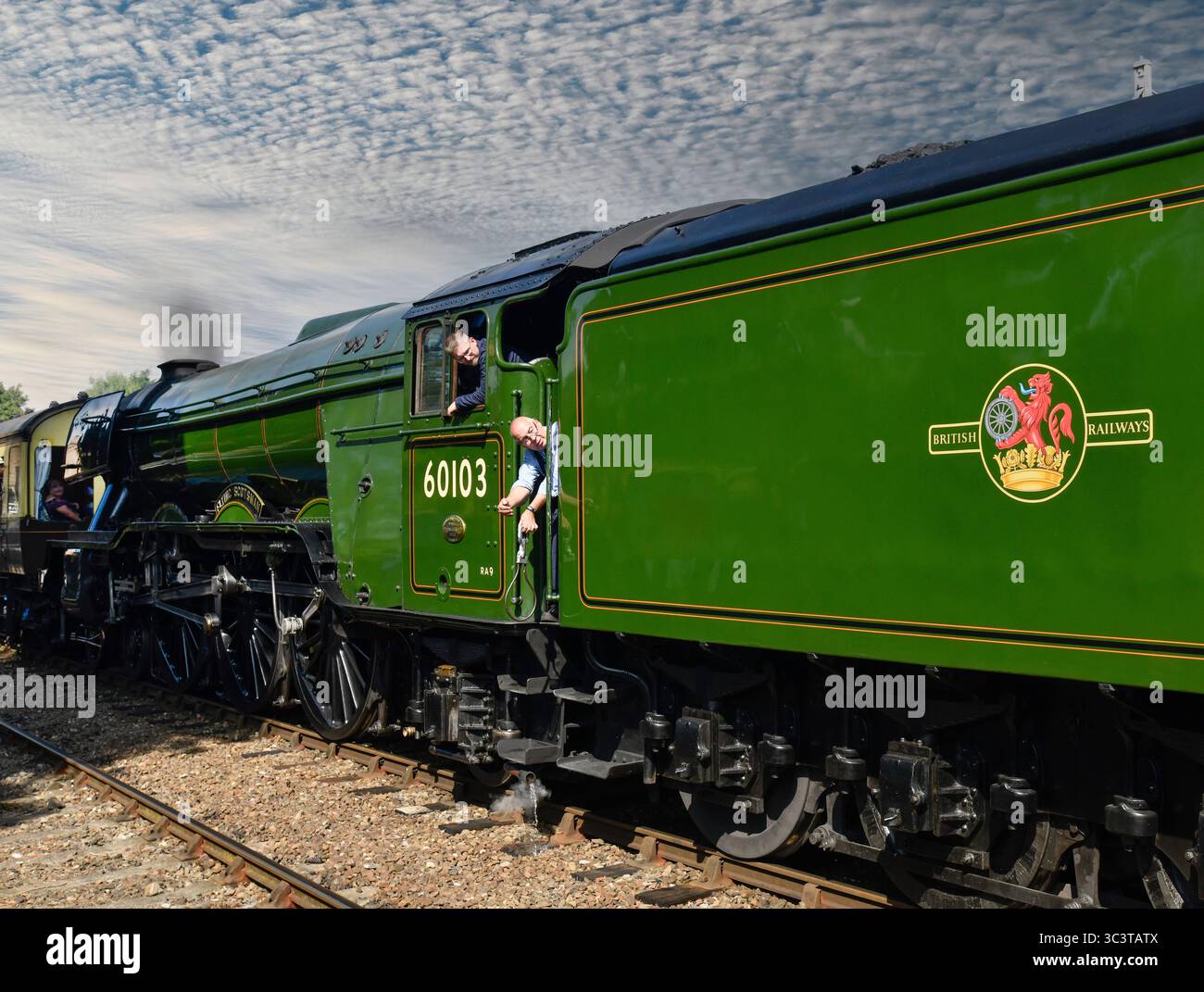 Die Flying Scotsman Dampflokomotive Feuerwehrmann, der bereit ist, Spielinstrumente auszutauschen, während der Zug durch den Bahnhof Hampton Loade am Severn Val fährt Stockfoto