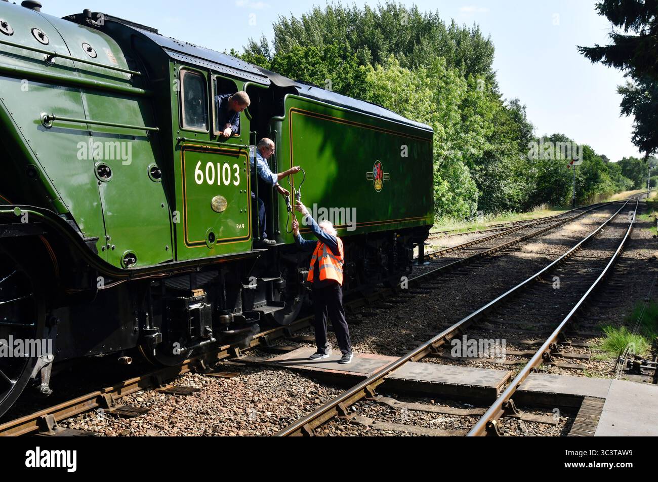 Die Flying Scotsman Dampflokomotive Feuerwehrmann und der Hampton Loade Signalgeber tauschen ihre Instrumente aus, wenn der Zug durch den Bahnhof Hampton Loade fährt Stockfoto