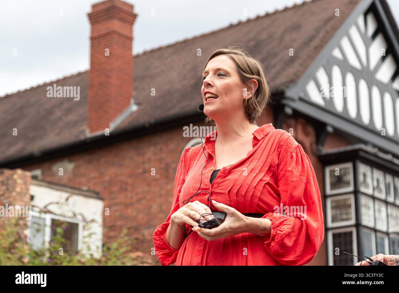 Birmingham, Großbritannien. Juli 2025. 300 Menschen treffen sich zusammen, um eine Tanzroutine namens Most Wuthering Heights Ever in Kings Heath, Birmingham, Großbritannien, aufzuführen. Die Teilnehmer, alle in rot gekleidet, wurden von Jess Phillips, Labour-Abgeordneter für Yardley, Birmingham, angesprochen, bevor sie das Musikvideo für Kate Bushs ikonisches Lied „Wuthering Heights“ reproduzierten. Die Veranstaltung sammelt Gelder für Women's Empowerment and Recovery Educators und ANAWIM Charitations. Quelle: Peter Lopeman/Alamy Live News Stockfoto
