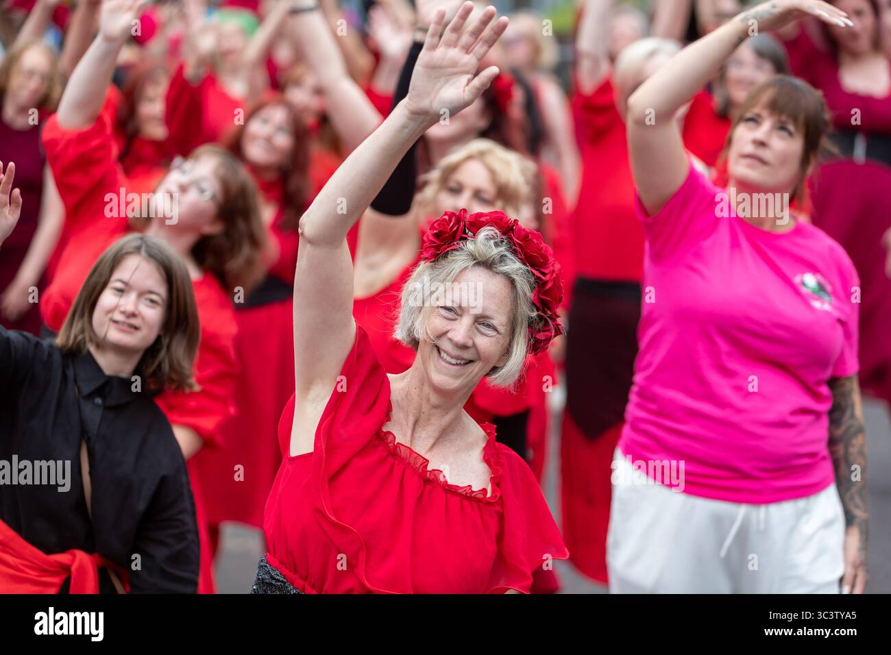 Birmingham, Großbritannien. Juli 2025. 300 Menschen treffen sich zusammen, um eine Tanzroutine namens Most Wuthering Heights Ever in Kings Heath, Birmingham, Großbritannien, aufzuführen. Die Teilnehmer, alle in rot gekleidet, wurden von Jess Phillips, Labour-Abgeordneter für Yardley, Birmingham, angesprochen, bevor sie das Musikvideo für Kate Bushs ikonisches Lied „Wuthering Heights“ reproduzierten. Die Veranstaltung sammelt Gelder für Women's Empowerment and Recovery Educators und ANAWIM Charitations. Quelle: Peter Lopeman/Alamy Live News Stockfoto