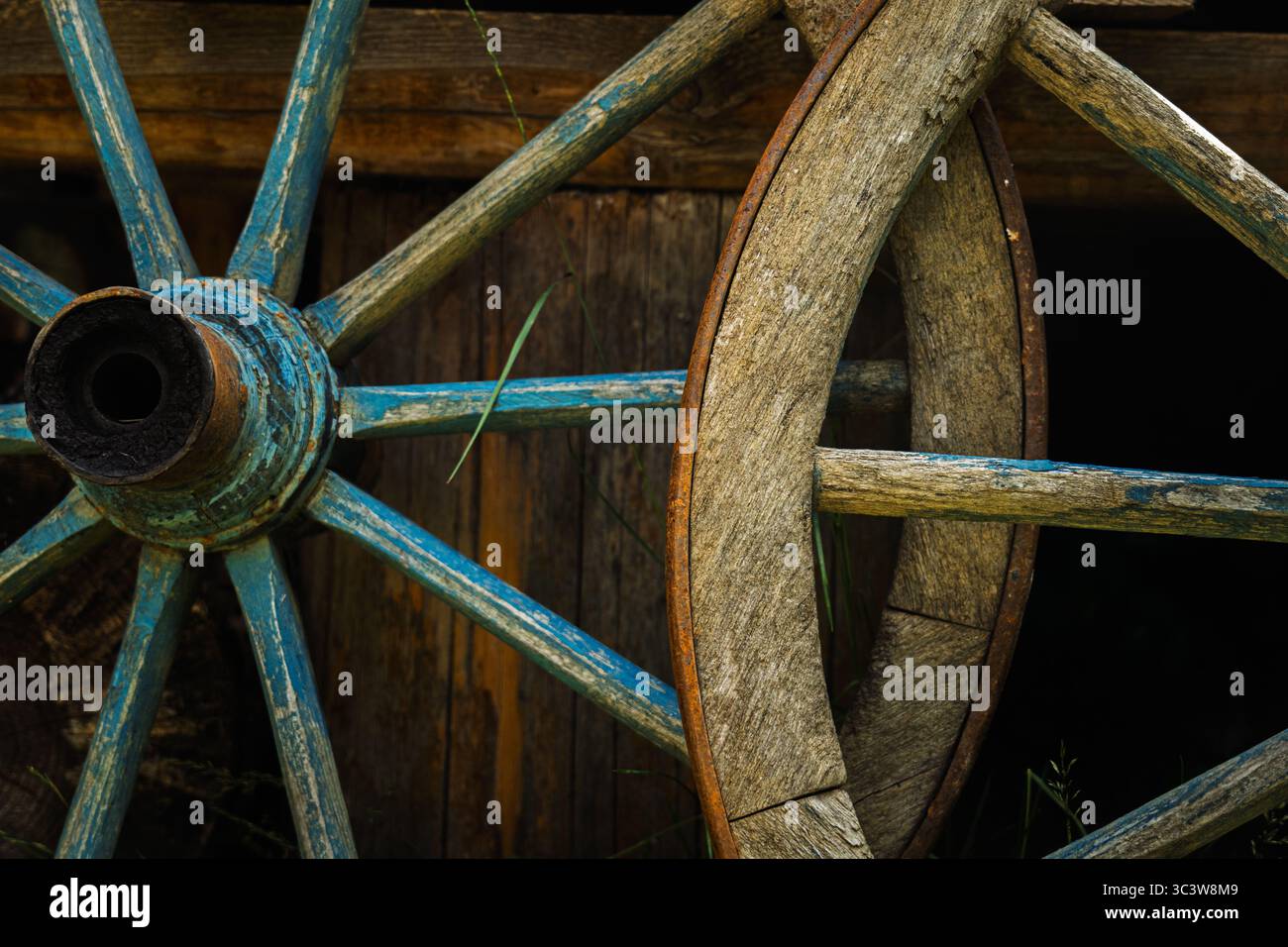 Nahaufnahme der Kreuzung alter hölzerner Wagenräder mit Eisenfelgen Stockfoto
