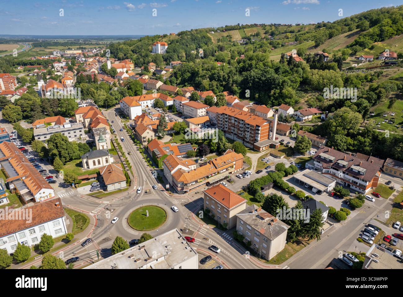 Drohnenfoto der malerischen slowenischen Stadt Lendava mit traditionellen roten Ziegeldächern, zentralem Verkehrskreisverkehr und Wohnbu Stockfoto