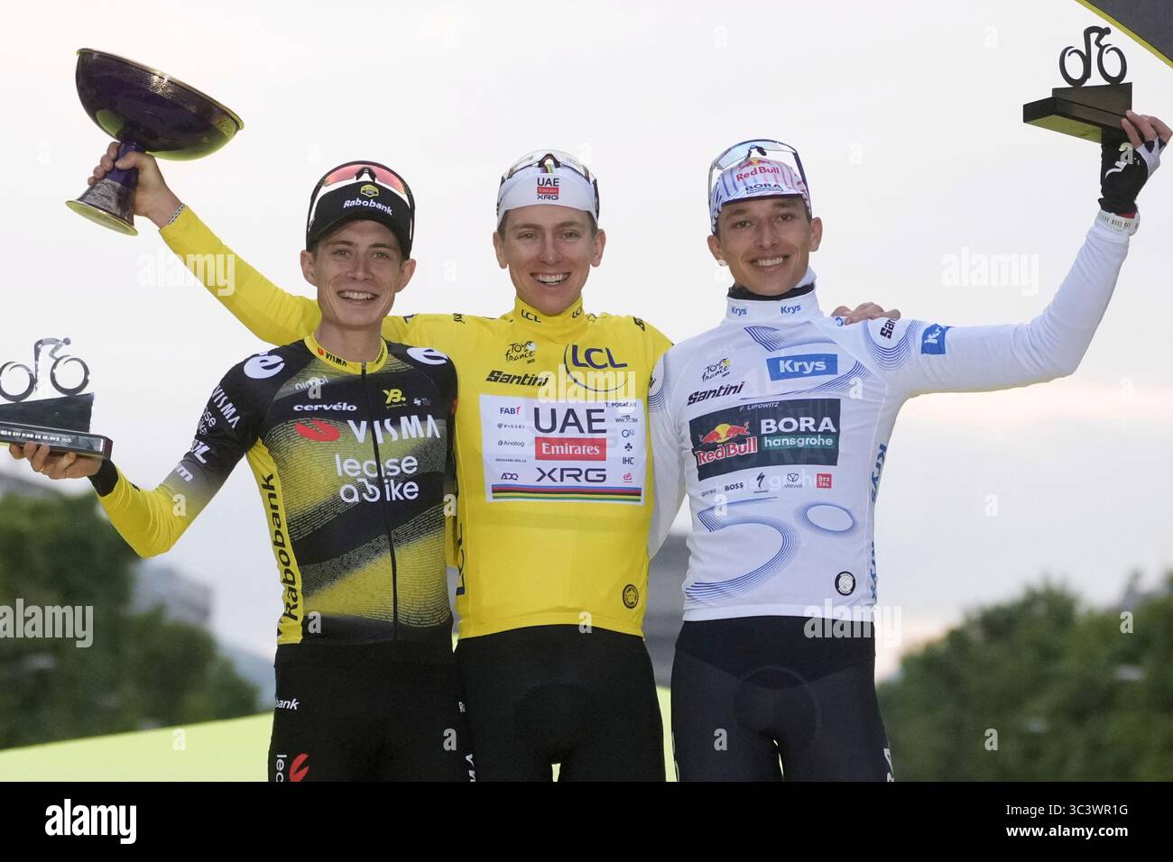 Tour de France winner Tadej Pogacar of Slovenia celebrates on the podium with second-placed Denmark's Jonas Vingegaard, left, and third-placed Germany's Florian Lipowitz, wearing the best young rider's white jersey, after the twenty-first stage of the Tour de France cycling race over 132.3 kilometers (82.1 miles) with start in Mantes-la-Ville and finish on the Champs-Elysees in Paris, France, Sunday, July 27, 2025. (AP Photo/Thibault Camus) Stockfoto