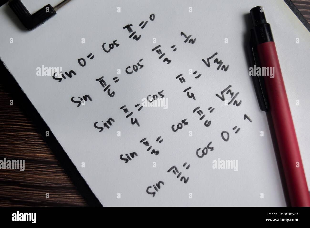 Das Konzept ähnlicher trigonometrischer Funktionen schreibt auf Buch isoliert auf Holztisch. Stockfoto