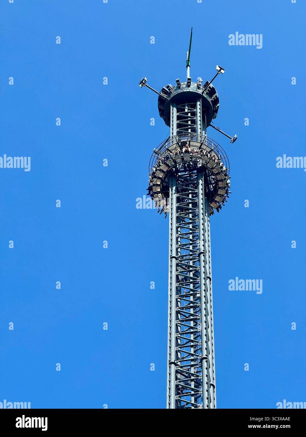Fahrt mit dem Fallturm in großer Höhe im Vergnügungspark Hansa Park in Deutschland vor klarem blauem Himmel. - Smartphone-aufgenommenes Stockfoto