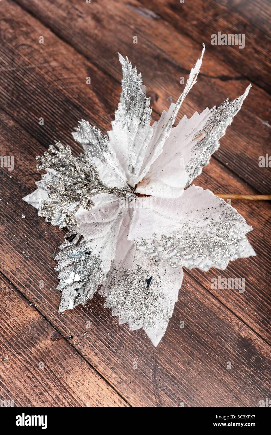 Glitzernde Weihnachtsstern, die nicht mittig auf hölzernem Hintergrund platziert sind. Kreatives, handgefertigtes Weihnachtsdekor für saisonales Design und flache Projekte. Stockfoto