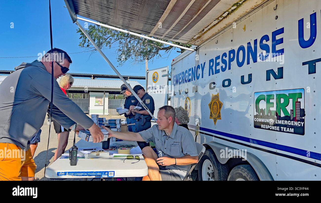 EMPORIA KANSAS, USA - 27. JULI 2025 örtliche Bewohner des Lyon County stellen sich an, um von Jarrod Fell dem Lyon County Kansas Direktor des Notfallmanagements ein Wetterwarnradio zu erhalten, FEMA stellte Mittel für den Kauf von vierhundert Einheiten bereit, die auf dem County Fairgrounds zu Beginn der jährlichen County Fair verschenkt wurden. Stockfoto