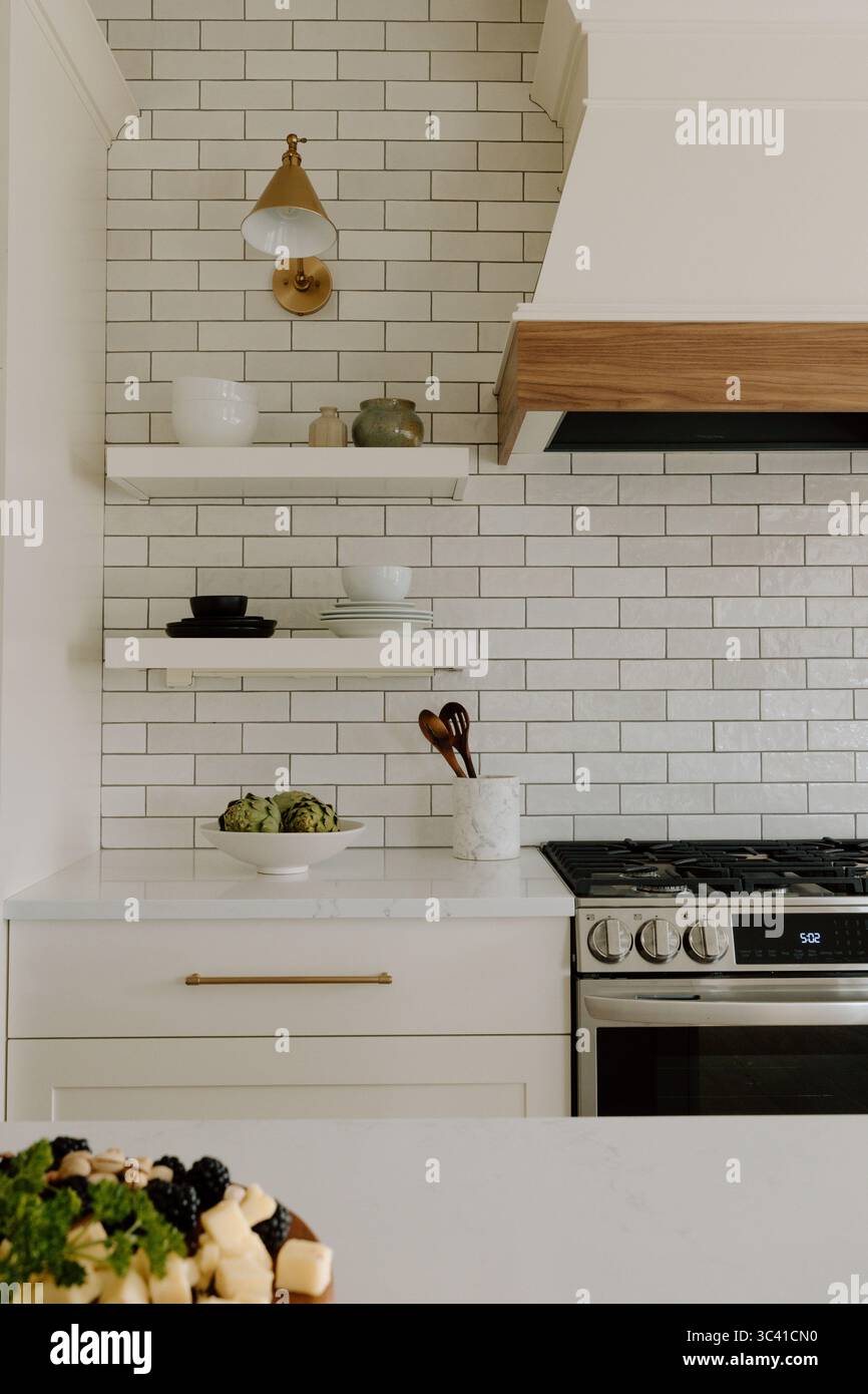 Moderne Bauernküche mit Fliesen und offenen Regalen Stockfoto