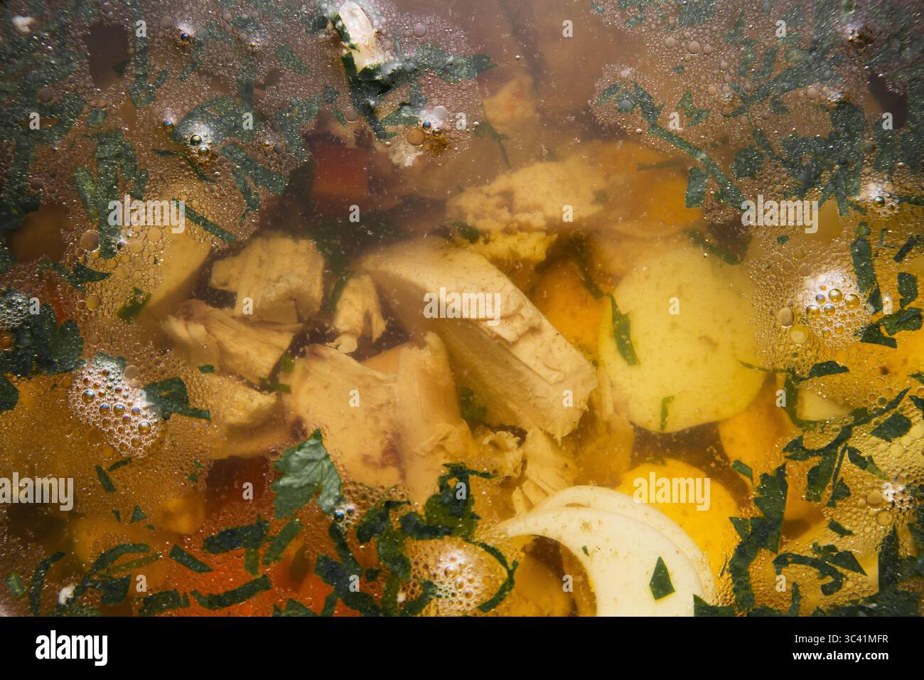 Durchsichtige Hähnchensuppe mit Hähnchenfilet, Kartoffeln, Karotten und Zwiebeln. Stockfoto