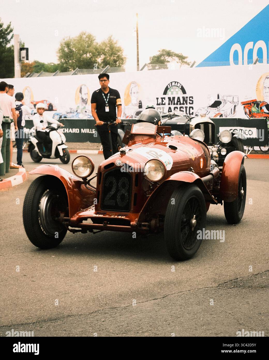 Le Mans, Frankreich - 07. Juni 2025: Unter dem bewölkten Himmel in der Nähe des Place Luigi Chinetti leuchtet ein Oldtimer-Rennwagen, der den Geist von Le Mans Classic verkörpert. Stockfoto