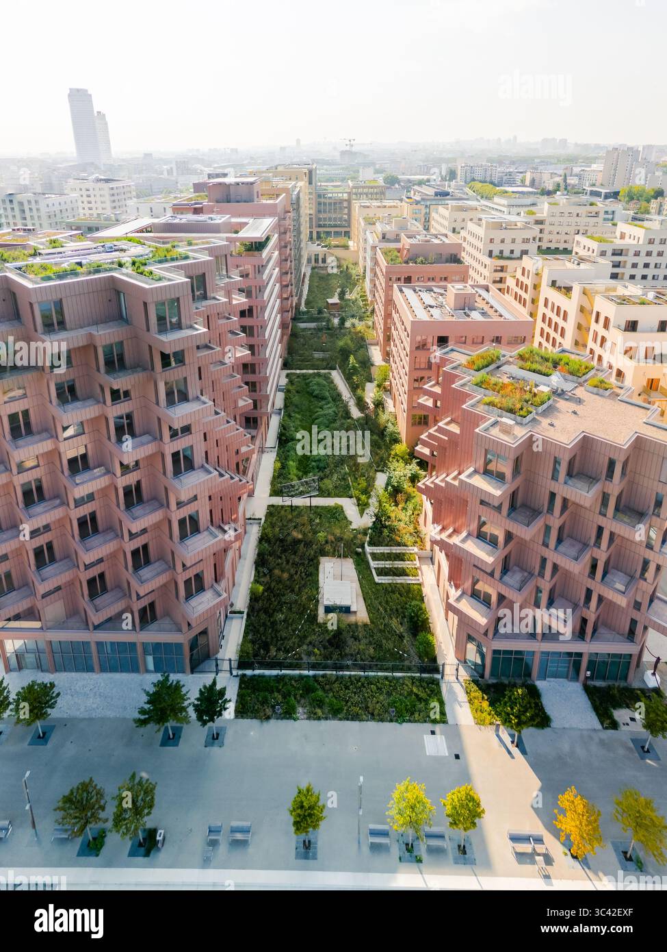 Aus der Vogelperspektive des Pariser Olympischen und Paralympischen Dorfes 2024, das einen lebhaften Grünbereich im Village des Athlètes Olympiques, Saint-Ouen-sur-seine, Île-de-France, Frankreich, flankiert. Stockfoto