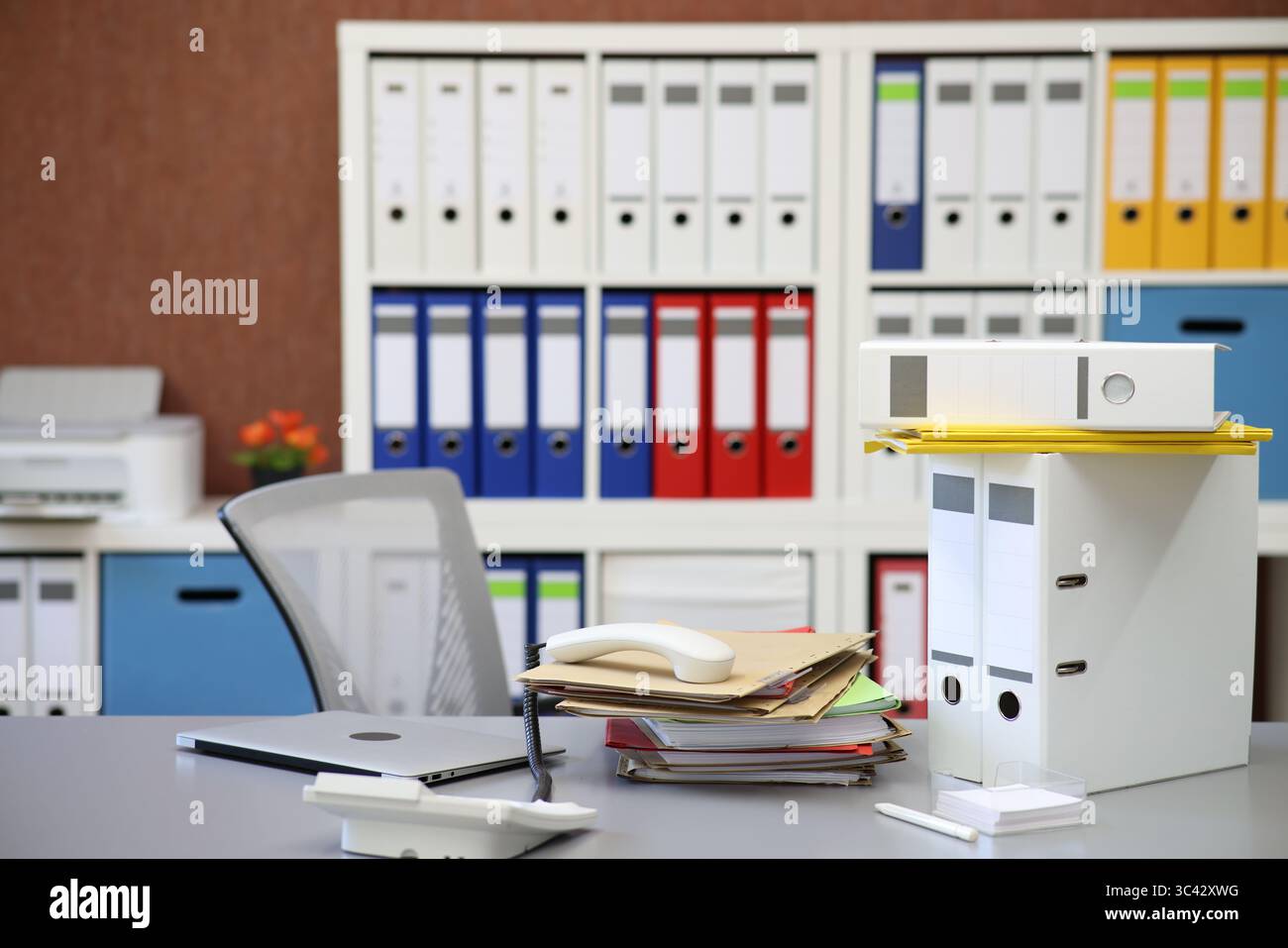 Leeres Büro mit Telefonempfänger und vielen Akten Stockfoto