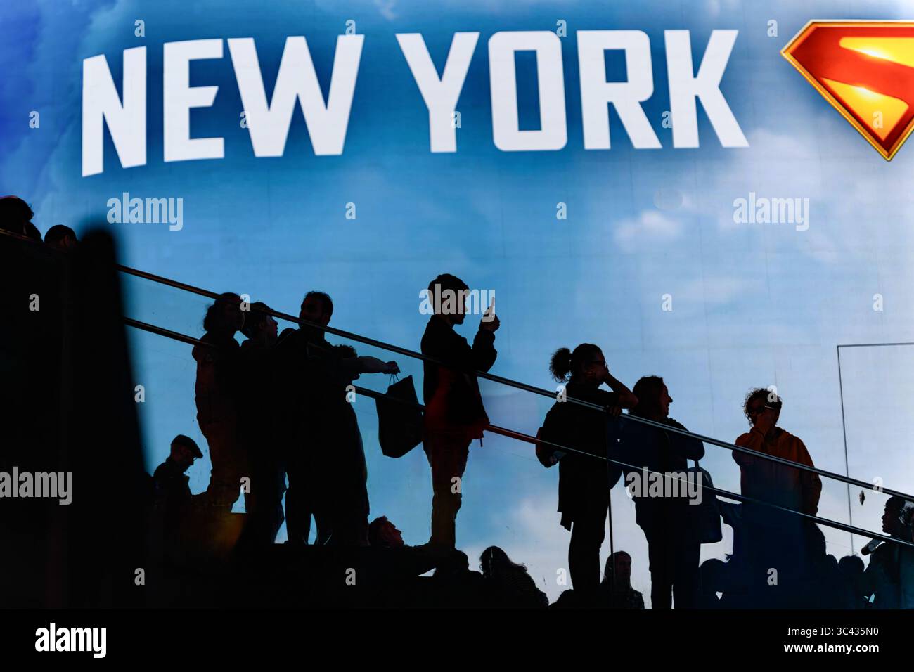 Silhouette Eines Mannes, der Telefonfotos unter Einer Menge auf den TKTS-Stufen vor Einer riesigen digitalen Reklametafel am Times Square, New York, USA macht. Stockfoto