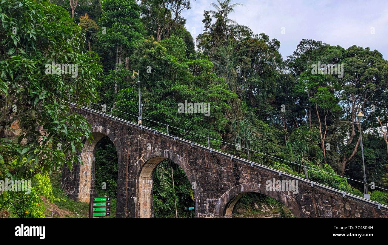 Die atemberaubende Fotografie bei Sonnenuntergang entfaltet sich in den Batu Caves Malaysia, wo der Himmel der goldenen Stunde auf Stadtturmlichter und Straßenbeleuchtung trifft. Von Stockfoto