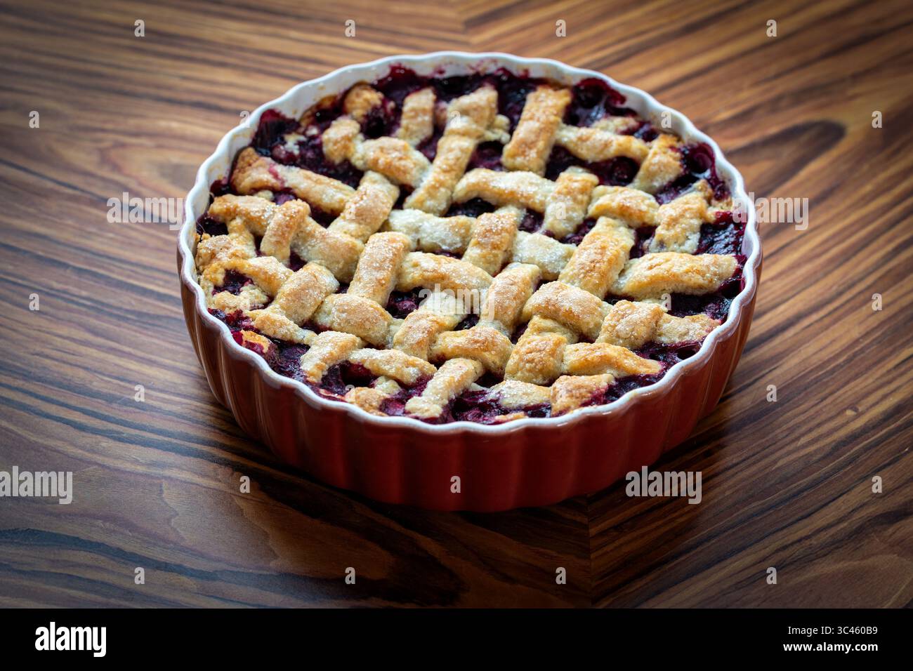 Hausgemachte Heidelbeerkuchen mit Gitterkruste in roter Schale Stockfoto