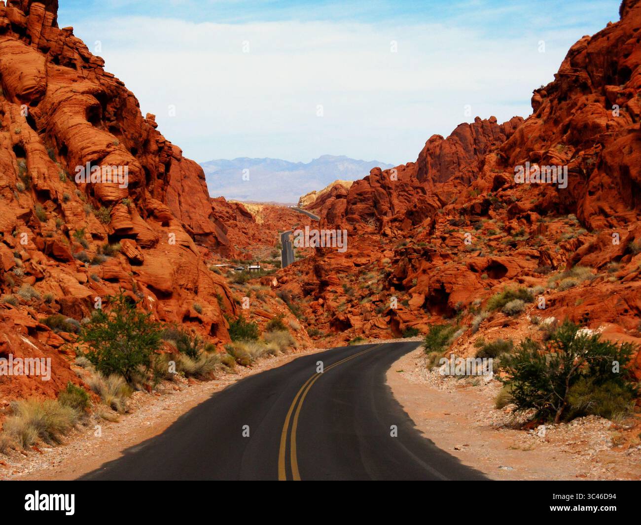 Die geteerte Straße führt durch die leuchtend dunkelroten Felsen des Valley of Fire State Park in Nevada Stockfoto