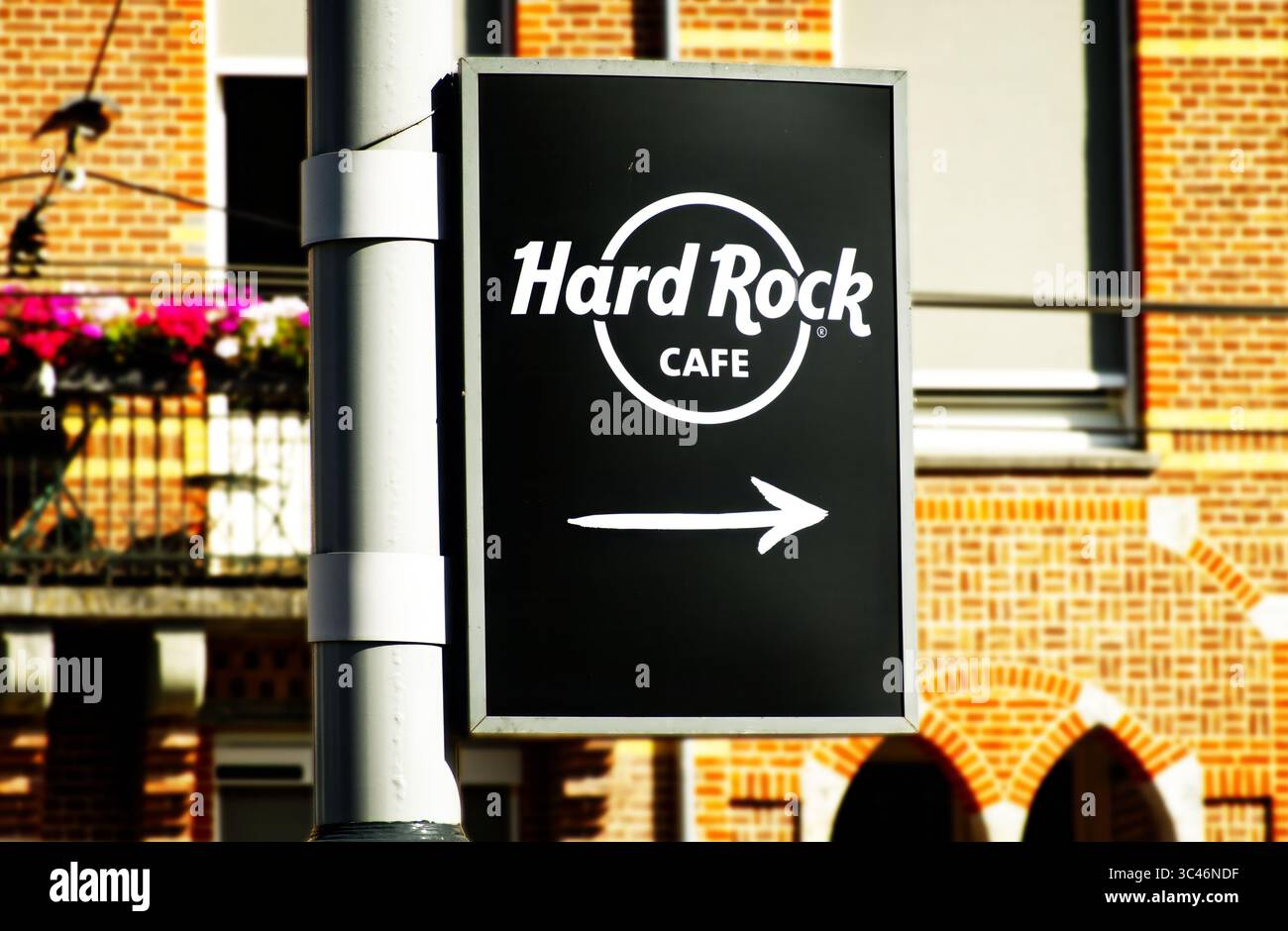Amsterdam, niederlande, 12. juli 2025, schwarzes Schild mit einem weißen Pfeil nach rechts, der zu einem Themenrestaurant in amsterdam führt, mit einem verschwommenen Schild Stockfoto