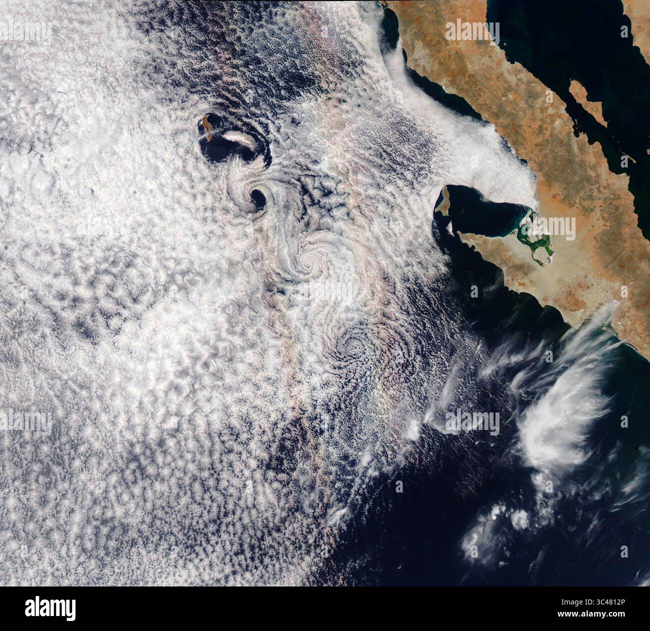 26. Juni 2018 – Weltraum – wenn Sie jemals eine Reihe konzentrischer Farbringe in der Nähe eines Nebels oder Nebels gesehen haben, haben Sie wahrscheinlich einen Ruhm gesehen. Dieses farbenfrohe optische Phänomen, außen hellrot und in der Mitte blau, entsteht, wenn Wassertropfen das Sonnenlicht zurück auf eine Lichtquelle streuen. Während MODIS die Erdoberfläche aus einer Höhe von etwa 700 Kilometern (400 Meilen) abtastet, macht es Schwaden senkrecht zum Weg, dem der Satellit folgt. Eine einzelne Schwade zeigt also einen horizontalen Querschnitt durch den Glory-Kreis, der zwei farbige Bereiche enthält. Das Ergebnis: Ein Ruhm in einem natürlichen Farbton Stockfoto