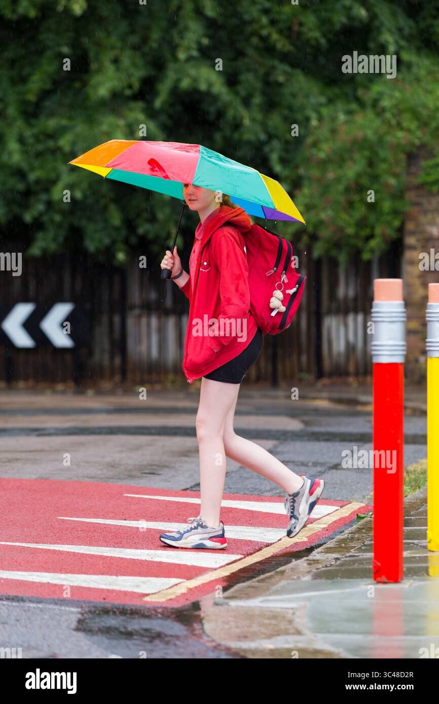 11-jähriges Mädchen/Schüler überquert die Straße/Straße mit farbigen Verkehrspollern in Form von Bleistift/Bleistiften. Twickenham. London. UK. (145). Stockfoto