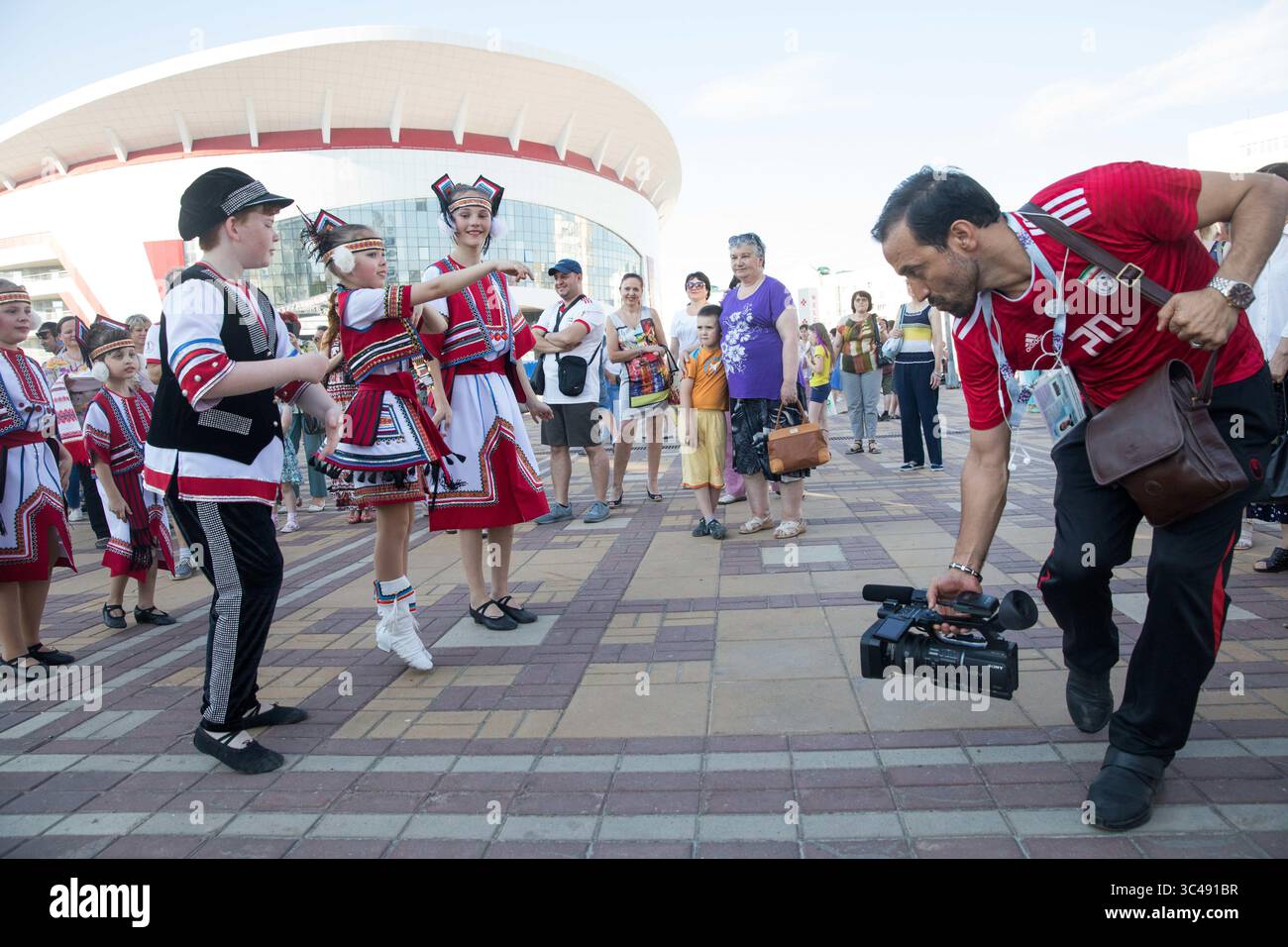 25. Juni 2018 - Saransk, Russland - SARANSK, RUSSLAND - 25. Juni 2018: Ein Iran-Fan nimmt Video von einigen russischen Folk-Künstlern auf dem Millennium Square in Saransk vor dem Gruppenspiel der FIFA-Weltmeisterschaft 2018 in der Mordovia Arena auf. (Kreditbild: © Douglas Zimmerman/ISIPhotos via ZUMA Wire) Stockfoto